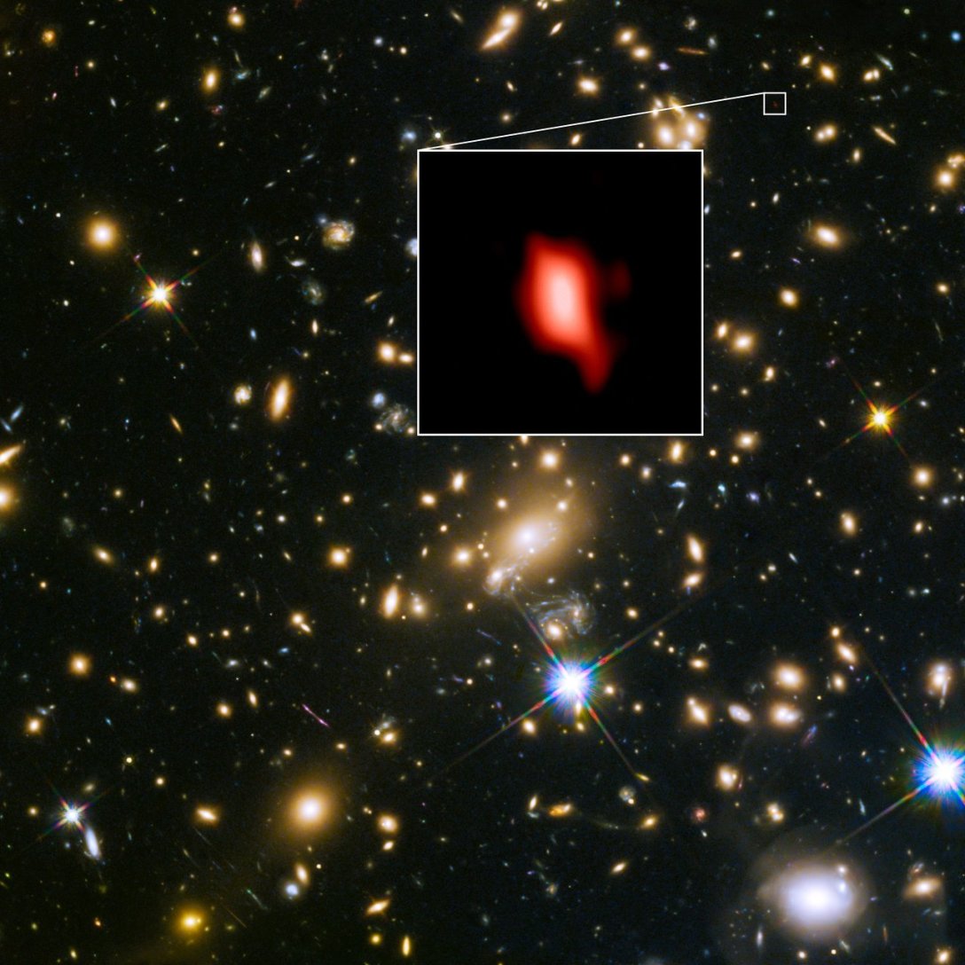 Галактический кластер MACS J1149.5 + 2223, снятый с космического телескопа NASA / ESA Hubble; вставка представляет собой очень далекую галактику MACS1149-JD1, которую видели 13,3 миллиарда лет назад и наблюдали с ALMA. Здесь распределение кислорода, обнаруженное с помощью ALMA, изображено красным цветом.